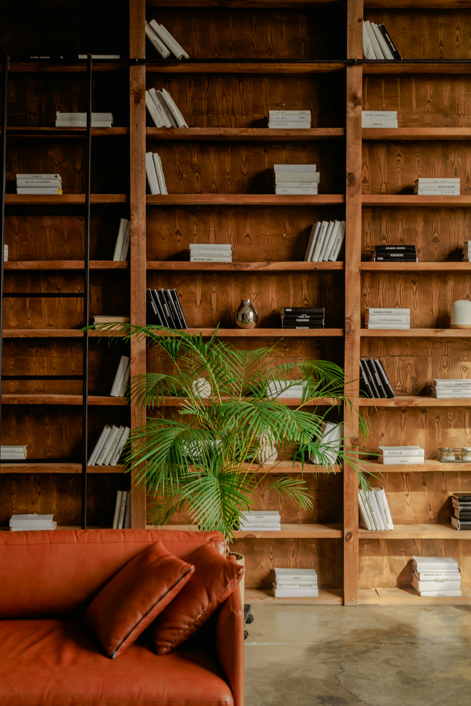 Floor-to-ceiling wooden bookshelves with a leather reading sofa