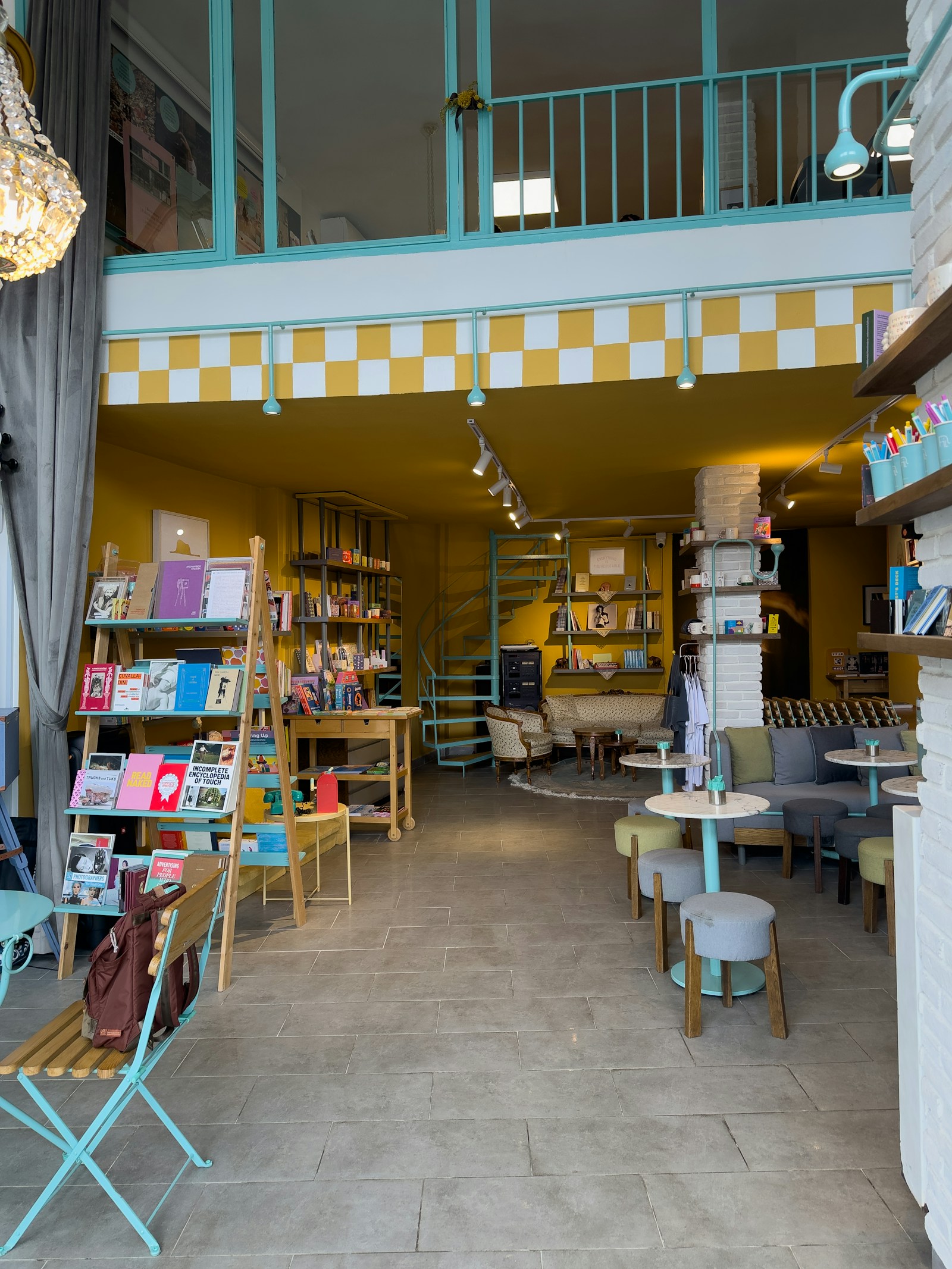 Bright, colourful independent bookshop interior with book ladders, seating and stationery